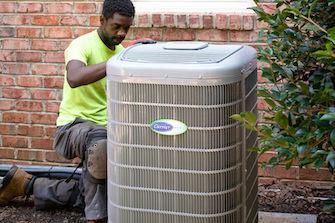 HVAC service professional working on an air conditioning unit in Raleigh